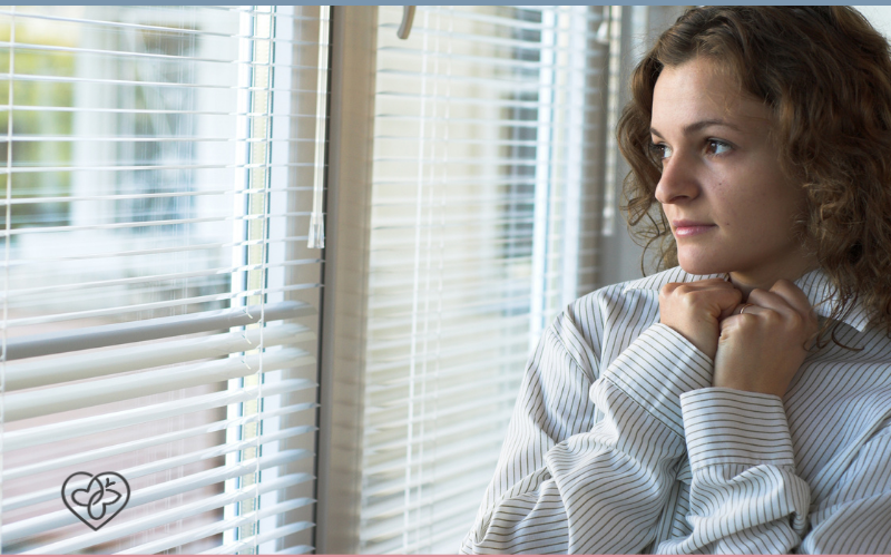 woman looking sadly out window