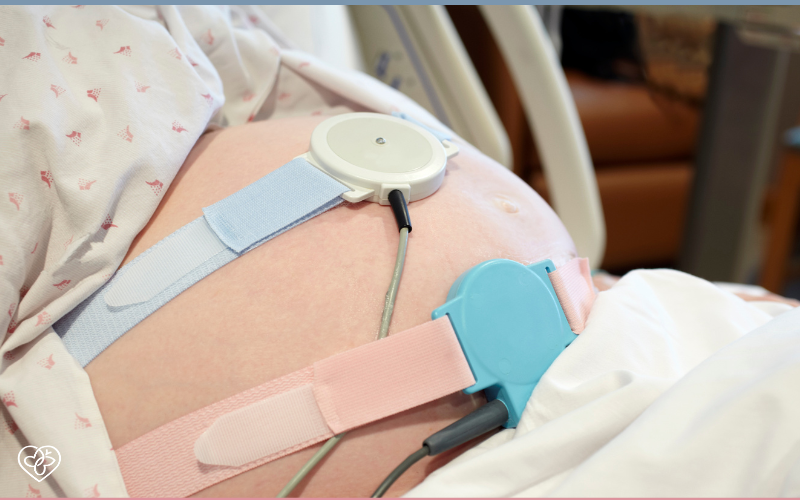 pregnant woman's stomach strapped with medical equipment